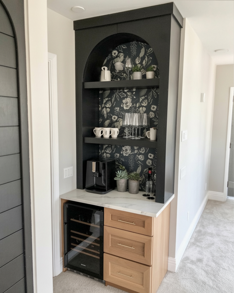 Close-up of a bold backsplash behind a coffee and wine bar: white marble with gray veining,  espresso machine, glass decanters, softly glowing under-cabinet lighting
